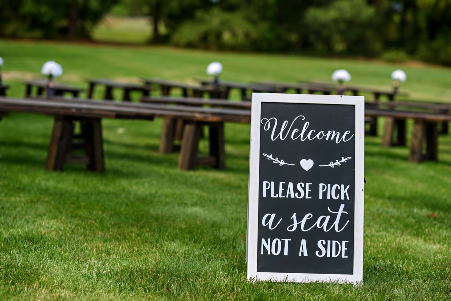 A sign at the wedding ceremony that says to pick a seat not a side.